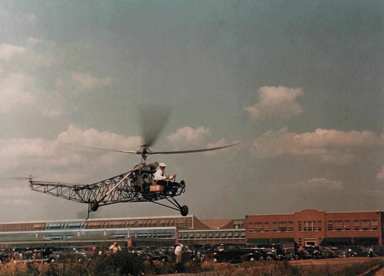 A rare color photo of Igor Sikorsky in the VS-300 hovering over meadow across from the factory.